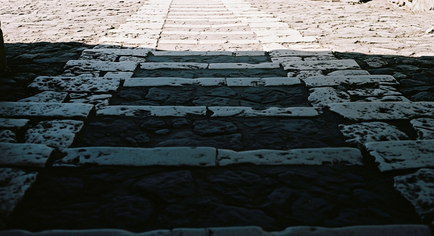 A stone path descending steeply into shadow, the destination hidden, the surface worn deeply by centuries of use